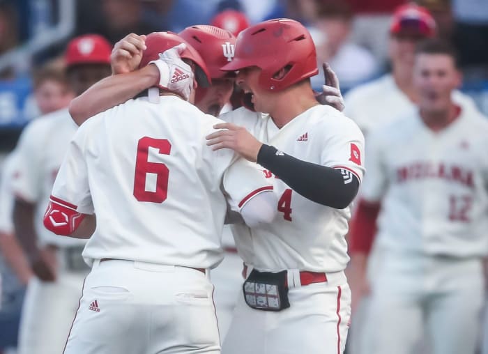 After Indiana's Peter Serruto (6) crosses home after hitting a three-run homer in the seventh, he gets a hug by teammates Josh Pyne, center, and Hunter Jessee as the Hoosiers went on to defeat Kentucky 5-3 Saturday night in the 2023 NCAA Regional at Kentucky Proud Park in Lexington.